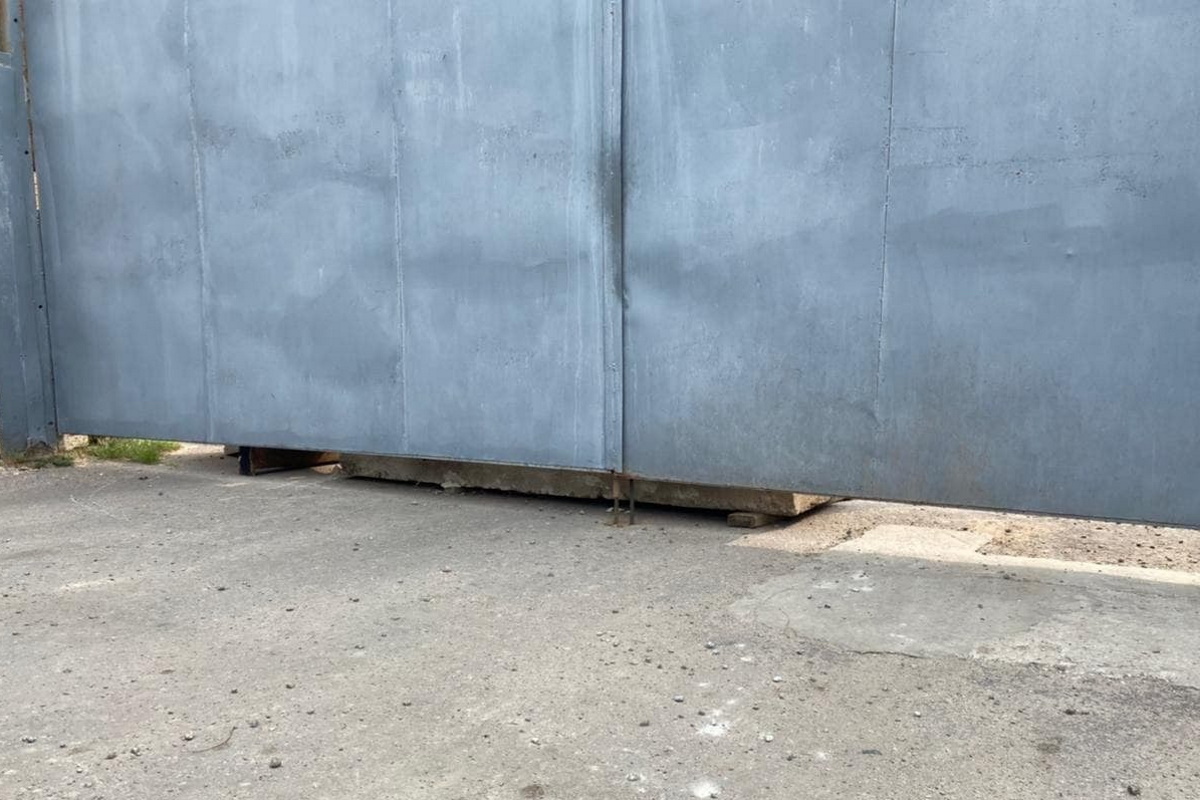 Изнутри забор подперли бетонными плитами.