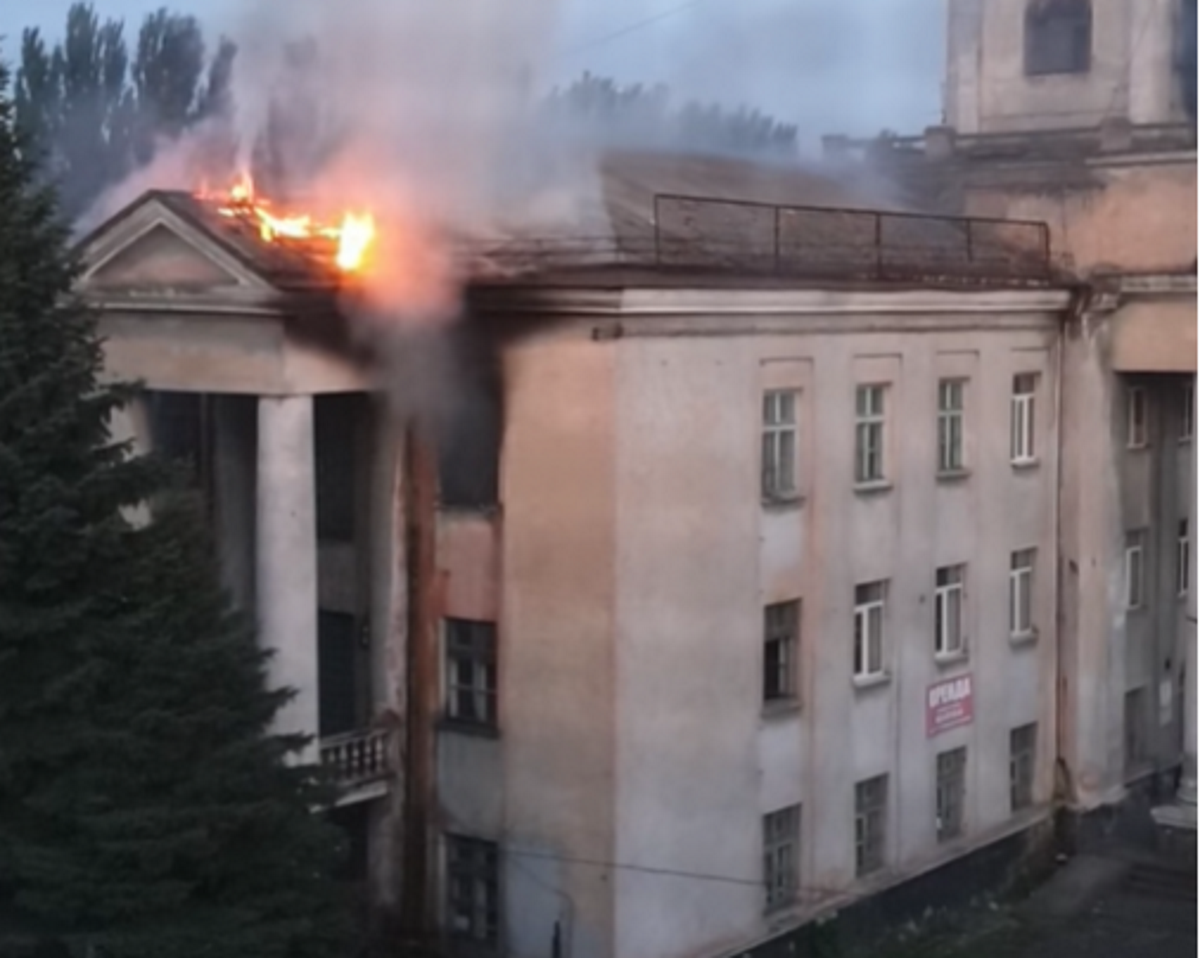 Пламя вырывалось из окон здания и перекинулось на крышу.